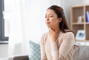 asian woman with sore throat at home