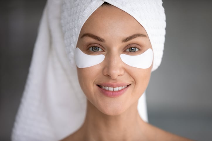 Smiling lady look at camera with eye patches on face