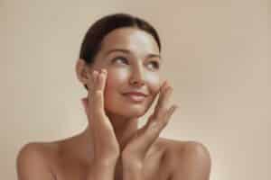 Skincare beauty photo of woman with clean, healthy skin touching her face after TRL treatment