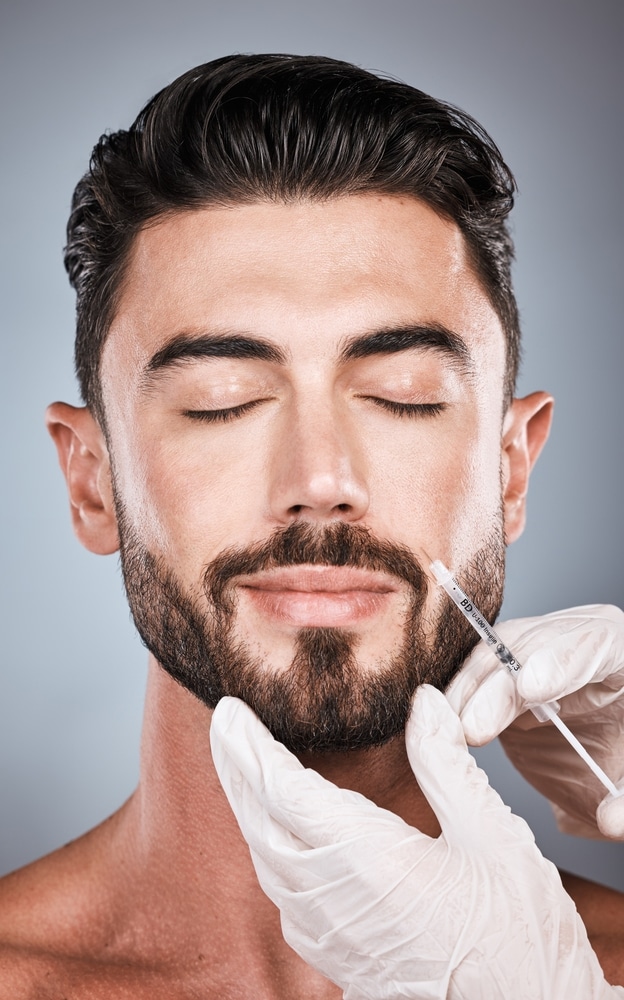 Man receiving face injection in beauty clinic, concept of skincare, collagen boost, and aesthetic treatment with Botox or PRP.